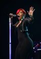 K. Michelle passionately performs on stage, showcasing her dynamic stage presence during her "Anybody Wanna Buy a Heart?" tour.