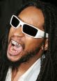 Lil Jon energetically shouting, wearing oversized sunglasses and grill, showcasing his iconic style and vibrant personality.