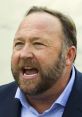 Alex Jones passionately speaking, showcasing his intense expression and distinctive beard during a public appearance.