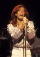 Robin Gibb passionately performing on stage, showcasing his iconic style and vocal talent as a member of the Bee Gees.