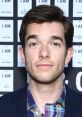 John Mulaney at an event, showcasing his comedic style and charm, connected to Spider-Ham character from animated films.