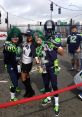 Fans dressed in Seattle Seahawks gear pose playfully, showcasing vibrant colors and passionate crowd noise atmosphere.