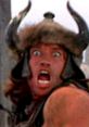 Arnold Schwarzenegger as Conan, showcasing fierce intensity with a horned helmet and dramatic expression in iconic scene.