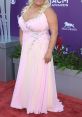 Beth Smith in a stunning pink gown with embellishments, posing confidently at the ACM Awards red carpet event.