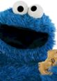 Cookie Monster from Sesame Street happily holds a chocolate chip cookie, showcasing his love for treats and fun.