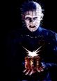 Pinhead from Hellraiser, holding a mysterious box that emanates eerie light, showcasing his menacing presence.