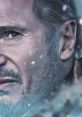 Liam Neeson's intense gaze amidst a snowy backdrop, showcasing emotion and depth in a compelling scene.