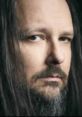 Close-up portrait of Jonathan Davis with long dark hair and piercing eyes, expressing intensity and focus.