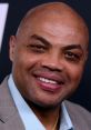 Charles Barkley smiling at an event, showcasing his charismatic personality and signature bald look.