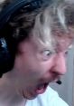 Excited reaction of a gamer with headphones, showcasing a surprised expression during a livestream session.