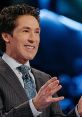 Joel Osteen delivering an inspirational sermon, showcasing his signature smile and engaging hand gestures.