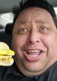 Joseph "Joey" Hernandez, known for JoeysWorldTour V2, excitedly holds a tasty breakfast sandwich in his car.