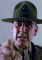 Sargent Hartman shouts commands, embodying a stern military drill instructor's intensity and authority.