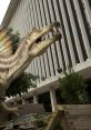 Spinosaurus statue with a dynamic pose, showcasing its unique sail and fierce features near a modern building.