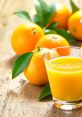 Freshly squeezed Orangensaft in a glass next to ripe oranges and green leaves on a rustic wooden table.