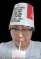 Asian Andy wearing a humorous bucket hat and sipping a drink, showcasing a playful and quirky personality.