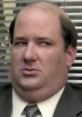 Kevin Malone looking skeptical in a business suit, showcasing his classic deadpan humor from the iconic TV show "The Office.