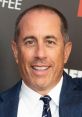 Jerry Seinfeld smiles at a red carpet event, showcasing his signature style and charm. Enjoying new comedic moments.