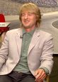 Owen Wilson smiling during an interview about Lightning McQueen from Pixar's Cars, showcasing his signature charm.