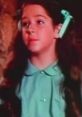 Young girl with long hair and a green outfit, showcasing Sherrie Wills' early acting charm and talent in classic film.