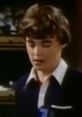 Young boy with short brown hair wearing a dark blazer, looking thoughtful in a nostalgic setting, reminiscent of Chip Courtland.