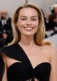 Margot Robbie smiles confidently at a high-profile event, showcasing her elegant black gown and radiant beauty.