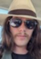 Individual wearing a wide-brimmed hat and sunglasses, embodying the laid-back vibe of Mungo Matty Mouthfulls.