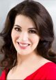 Nigella Lawson smiling in a vibrant red dress, showcasing her signature style and charm in culinary media.