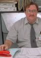 Frustrated office worker surrounded by paperwork, embodying the humor of "Office Space" (1999) in a cubicle setting.