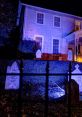 Haunting Halloween decor featuring illuminated gravestones and a spooky house illuminated in eerie blue light.