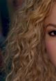 Close-up of Shakira showcasing her iconic curly hair, reflecting the emotional depth of "Nunca Me Acuerdo de Olvidarte.