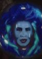 Madame Leota appears in a crystal ball, featuring vibrant blue hair and mystical glowing effects, exuding psychic energy.