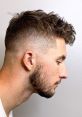 Stylish fade haircut with textured curls on top, showcasing a clean skin fade on the sides for a trendy look.