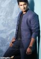 Jiiva in a stylish blue jacket and black t-shirt, posing confidently against a textured backdrop.