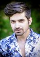 Stylish portrait of Vishalsingh with a trendy hairstyle, wearing a floral shirt against a lush green backdrop.