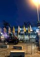 Deluta branding visible on flags outside a venue, with a telehandler in the foreground and evening lighting.