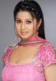 Elegant woman in pink traditional attire with intricate embellishments and jewelry, showcasing beauty and grace.