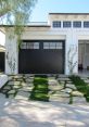 Stylish modern garage doors with decorative landscaping and stone walkway, enhancing curb appeal and functionality.