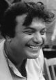 Uttam Kumar smiling joyfully, showcasing his iconic charm in a nostalgic black-and-white portrait.