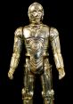 C-3PO figurine, iconic Star Wars protocol droid, showcasing shiny gold finish and detailed design against a black background.