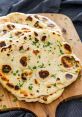 Naan The rich aroma of freshly baked Naan fills the air, enticing all the senses. As you take a bite into the warm, fluffy