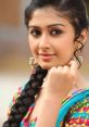 Young woman in colorful traditional attire with a braid and earrings, showcasing Desi culture and style.