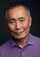 George Takei, renowned actor and activist, smiles warmly in a purple shirt against a dark background.