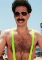 Huge Borat sporting neon suspenders and sunglasses, showcasing a playful summer vibe on a beach.