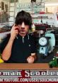 Sol Rosenberg from Jerky Boys talking on the phone in a garage with tools and scooters in the background.