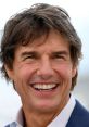 Tom Cruise smiling at an event, showcasing his signature charm and confident demeanor in a stylish suit.