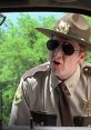 Close-up of a state trooper in shades, iconic scene from Super Troopers showcasing comedic law enforcement antics.