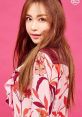 Portrait of a woman with long hair, wearing a floral blouse against a vibrant pink background. Captivating and stylish look.