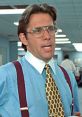 Bill Lumbergh from Office Space, wearing glasses and a patterned tie, embodies corporate monotony in an office setting.