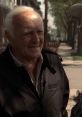 Paulie Walnuts converses on the street, showcasing his iconic personality in a classic mob setting.